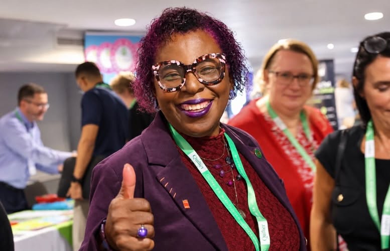 A guest smiling and giving a thumbs up among the crowd at a networking gathering